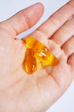 Omega 3 ve Omega 6 kapsülleri avucunuzun içinde, vitamin alıyorlar.. 