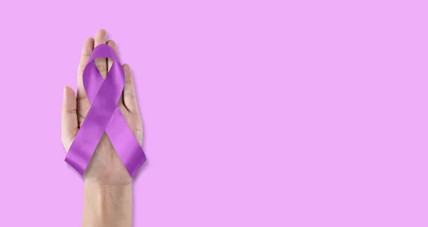 Purple awareness ribbon for World cancer day and World Alzheimers day (month) concept, bow on helping hand support isolated with clipping path on Lavender background