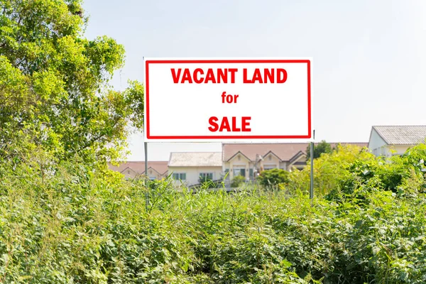 Advertising billboard immersed in a rural scene with Vacant Land for Sale written on it - image with copy space. Land or landscape of green field in aerial view. Include agriculture farm.
