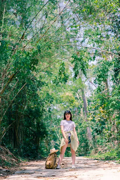 森の中に幸せに立つ女性旅行ライフスタイルウェルネスコンセプトタイの自然と調和したアウトドアホリデーアドベンチャー — ストック写真