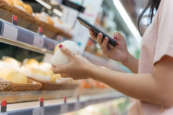 Die Junge Frau Kauft Mit Dem Handy Der Hand Lebensmittel — Stockfoto