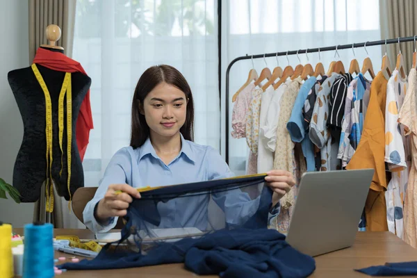 Designer concept.The dressmaker is designing an evening dress in the room.Asian clothing designers are measuring sample sizes to prepare evening gowns for important customer orders
