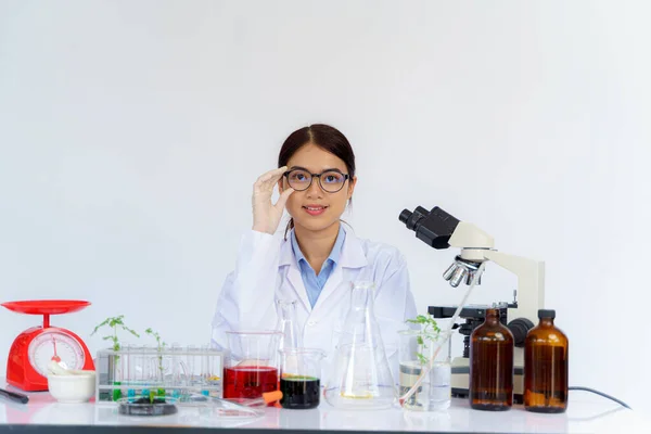 Žena Vědec Drží Své Brýle Při Pohledu Oběma Zkumavky Píše — Stock fotografie