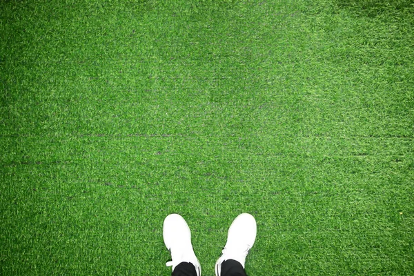 認識できない父と人工芝に対して立っている息子の足 スタジオは緑の背景で撮影 コピー スペース — ストック写真