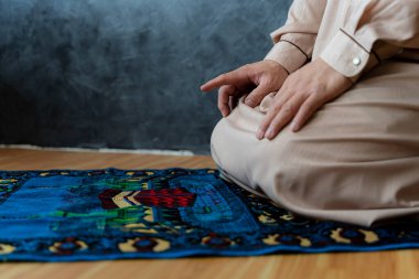 Müslüman adam içeride Tanrı 'ya dua ediyor. Müslüman erkekler Tashahhud duruşunda namaz kılıyorlar