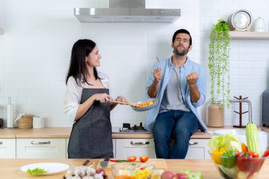 Mutfakta romantik bir çift. İyi bir zevkle yemek yiyen bir adam. Güzel, genç bir eş, gülümseyen kocasıyla salata pişiriyor. Akşam yemeği ya da kahvaltı bekliyor. Aile hafta sonu eğleniyor..