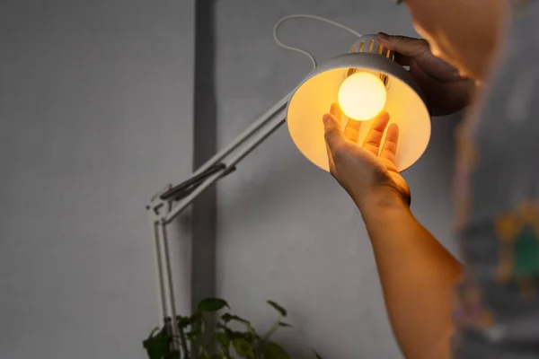 Led电灯泡在家中调光 服务员在更换公寓照明时 既要节能又要便宜的白炽灯 — 图库照片