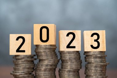 Yeni yıl, e-ticaret ve alışveriş çevrimiçi teknoloji, ekonomik kriz riski ve sorun konsepti için para biriktirme ve yönetme, ahşap masa üzerindeki 2023 ahşap metin bloğunu kapat