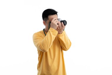 Başarılı profesyonel fotoğrafçı DSLR dijital kamera izo kullanıyor. Beyaz izole edilmiş fotoğraf stüdyosunda dijital kamera çeken profesyonel erkek fotoğrafçı..