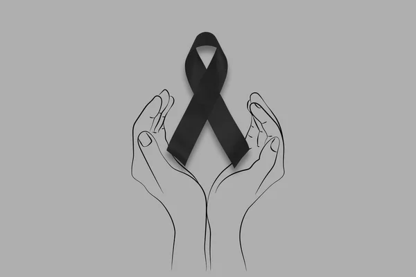 Hand hold black ribbon on background. Mourning is the grieving process. Melanoma and skin cancer, Vaccine injury awareness month and rest in peace concepts. Woman holding black Ribbon