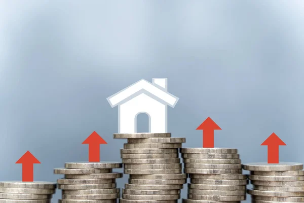 Residential or real estate property, land and building annual taxation. Rise up arrow and percentage icon on coin stack as chart step and white small house model, a red up arrow and house.