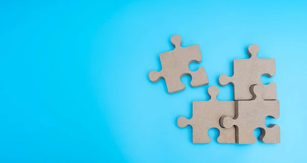 Wooden Jigsaw Puzzle parts on blue background. four puzzles form a rectangle on blue background. Wide view top view
