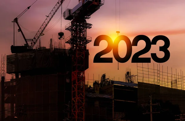 建筑工人轮廓与起重机和阴天 准备迎接2023新年派对和改变新的业务 商人工程师在建筑工地上看2023年的蓝图 — 图库照片
