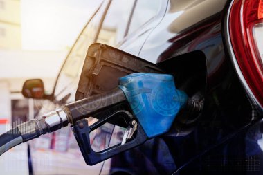 Benzin deposuna benzin doldurmak için bir benzin istasyonundan otomatikman benzin al. Bronz bir arabanın yakıt deposundaki benzin pompasını kapat. Benzin istasyonlarında araçlara benzin dolduruluyor..