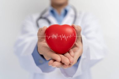 Doktorun elinde kırmızı kalp şekli ve sanal ekran tıbbi teknoloji ağı konseptine bağlı modern tıbbi ağ ikonu var. Tıbbi ve sabırlı.