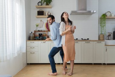 Modern mutfakta dans eden bin yıllık mutlu karı koca evlilik yıldönümünü birlikte kutluyor, mutlu genç çift kiracıları yeni ev ya da apartman dairesinde aile tatilinde eğleniyor.