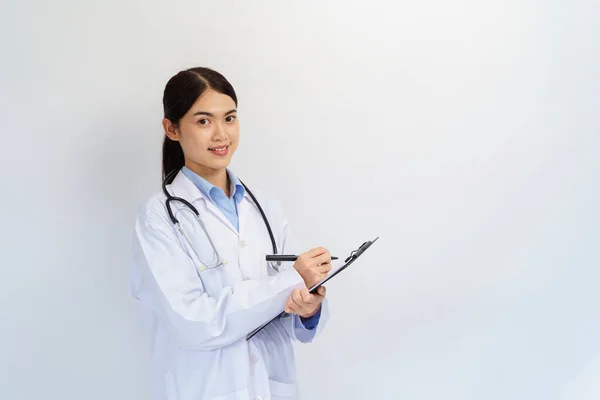 Concept of doctor and medical. Asian female Doctor hand taking note information of patient in paperwork checklist on clipboard with blue background.