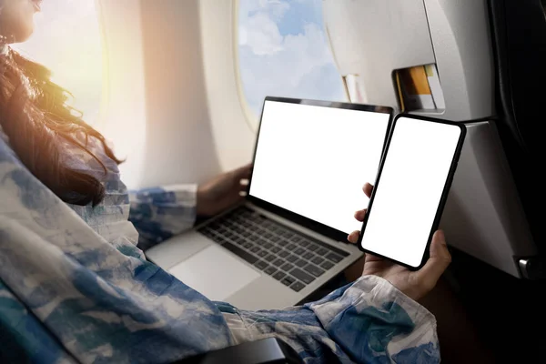 女性が飛行機に乗って モックアップ電話を持っている ビジネス そして仕事 スマートフォンとラップトップを使用している女性 旅行と航空技術は飛行機に座っている間スマートフォンを使用します — ストック写真