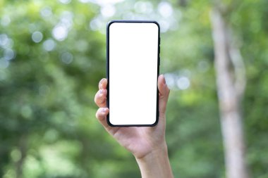 Yeşil soyut arkaplan üzerinde beyaz maket ekran ile el ele tutuşan akıllı telefon.