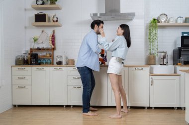 Romantik genç çift mutfakta birlikte yemek pişiriyor mutlu aşıklar genç çift modern mutfakta romantik dans eşleri gülümsüyor karı koca yıldönümlerini kutluyor..