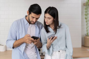 Gülümseyen adam ve kadın birlikte akıllı telefon ekranına bakıyor, genç çift komik videolar izliyor, sosyal ağlarda sohbet ediyor, mesajlarda iyi haberler okuyor, oyunlar oynuyor, online alışveriş yapıyor..