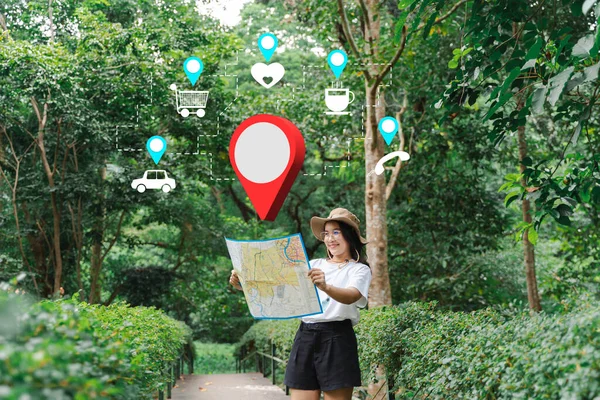 Female hand with map in forest background Happy young woman with a map traveling in nature travel concept. Hiking trail navigation app showing resting spots.