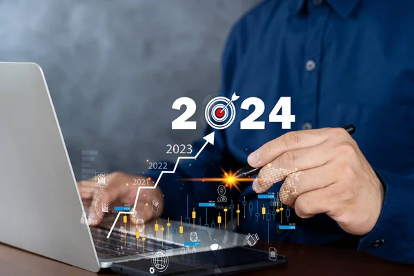 Businessman working on digital laptop computer with digital graph chart graphic, positive indicators in 2024, business calculate financial data, Digital marketing, finance, trade stock market concept.
