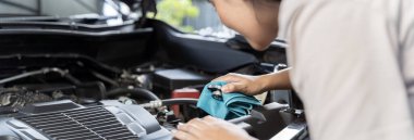 Check auto car's coolant level. That service, repair or maintenance by women hand to open cap of tank or reservoir for filling liquid cooled engine with water, antifreeze in radiator, cooling system.