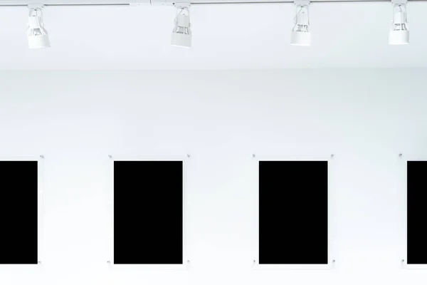 A row of black frames hang on a white wall, clipping path. They are all made of different materials. The frames add interest and visual appeal to the wall or other special mementos.