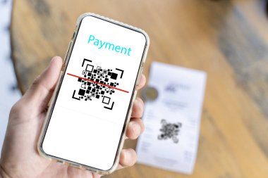 Male hand holding a smartphone with qr code on the screen. scanning the qr code. Barcode reader. Cashless technology, Digital money concept.