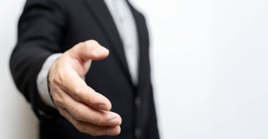 Elleri açık bir iş adamı anlaşmayı imzalamaya hazır ortaklar el sıkışıyor, el sıkışıyor, kopyalama alanı yaratıyor. İş ve ofis kavramı. El sıkışmaya hazır yakışıklı bir iş adamı..