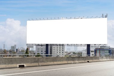 Otobanın kenarındaki boş reklam panosu. Reklam panosu bir şehirde yer alıyor ve otoyola bakıyor. Reklam panosu büyük ve dikdörtgen. İlan panosunun arka planı beyaz, kırpma yolu.