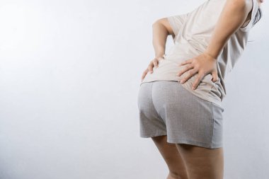 A woman holds his hands to the ass feeling pain. Hemorrhoids. Anus. Pain. Woman hand holding her bottom because having Abdominal pain and Hemorrhoids. Woman suffering from hemorrhoids, anal pain.