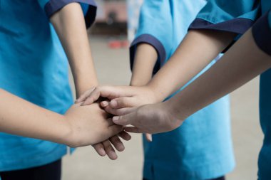 Dışarıda el ele tutuşan yetişkin ve çocukların yakınlaşması. Küçük çocuklar içeride el ele tutuşuyorlar. Birlik kavramı