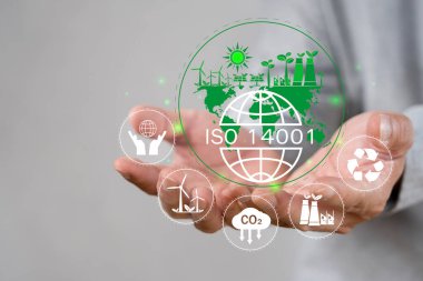 ISO 14001 konsepti. ISO 14001 'in çevresel yönetim sistemleri (EMS) sertifikalı sanal simgesine dokunan işadamı. Etkinliklerin çevresel etkilerini tanımlamak, kontrol etmek ve azaltmak.