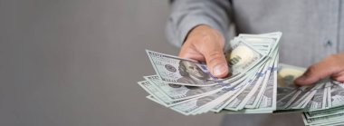 100 dolar ver. Amerikan Faturaları Elde, Nakit Uyarıcı Bağış. Sahtekar işadamı karanlıkta gizlice para dağıtıyor. Rüşvet, dolandırıcılık ve satıcılık kavramları.