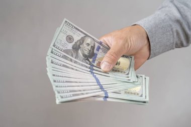 ABD Doları Sayan Bir Kişi. Elinde Amerikan doları banknotları tutan ve sayan birine yaklaş. 100 dolarlık banknotların el ele tutuşması.