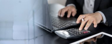 Ev finansmanı ve yazma notlarını hesaplamak için hesap makinesini kullanarak iş adamını kapat. Masada hesaplama, bütçe yönetimi. Finans, bütçe ve vergi hesaplamaları, aylık giderler
