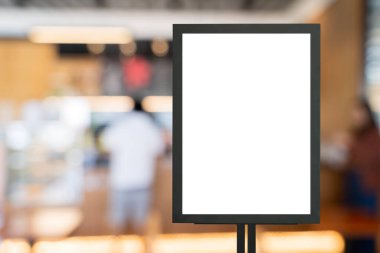 Kafe masasına poster çerçevesi şablonu ve iç mekan reklam afişini düzenle. Restoranın girişinde dikey boş reklam afişi var. Bir mağazanın içinde boş karatahta işareti.