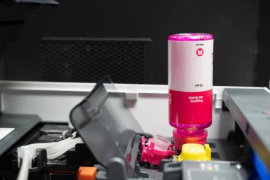 Mürekkep tankı yazıcılı mürekkep şişeleri. Ofisteki kırmızı mürekkep tankı yazıcısına mürekkep dolduruyorum. Devamlı mürekkep tedarik sistemi fişekleri ve konteynerleri