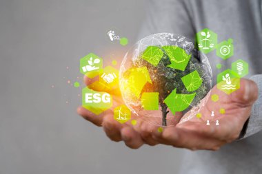 ESG çevre sosyal yönetim kavramı. Çevresinde ESG simgesi bulunan el ele tutuşan kristal küre. Sürdürülebilir bir çevre için iş birliği. Dünya sürdürülebilir çevre kavramı.
