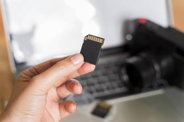 Kameralı SD kart. Dışarıdaki fotoğraf makinesine yüksek kapasiteli hafıza kartı yerleştiriyorum. Fotoğrafçının elinde fotoğraf makinesini hazırlamak için hafıza kartı var.. 