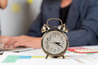 İşadamı masasında dinleniyor. Bilgisayarla birlikte masadaki çalar saatin kapanışı. Yanında çalar saatle dizüstü bilgisayarda çalışan serbest çalışan biri. Masadaki çalar saat. İş çalışıyor