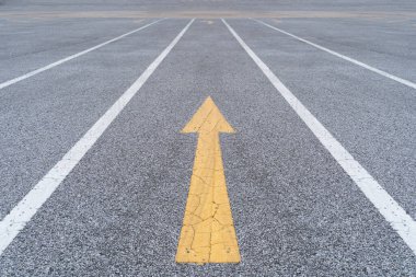 İş dünyasında bölücü fikirler. Kalın sarı ok asfalt yolda statükoya meydan okuyor, rekabetçi ortamlarda yaratıcılığı ve farklılığı simgeliyor