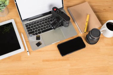 Gri arka planda iki SD hafıza kartı ve lens. Fotoğrafçı ekipmanı. Üst Manzara. Düz yatıyordu. Laptop, harici sabit disk, çevirmeli ekran ile modern dijital kamera.