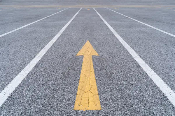 İş dünyasında bölücü fikirler. Kalın sarı ok asfalt yolda statükoya meydan okuyor, rekabetçi ortamlarda yaratıcılığı ve farklılığı simgeliyor