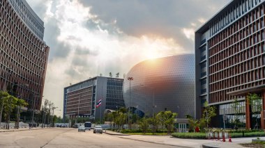 Bangkok binasının merkezindeki fantastik ofis binasının yapısal cam ön cephesi kıvrımlı çatısı. Ofis binasının alt manzarası gün doğumu, yansıma ve perspektifle yakınlaşır.