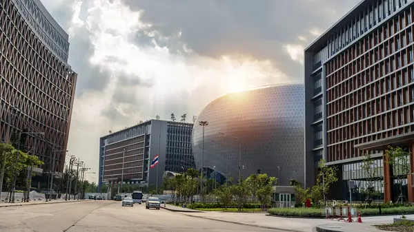 Bangkok binasının merkezindeki fantastik ofis binasının yapısal cam ön cephesi kıvrımlı çatısı. Ofis binasının alt manzarası gün doğumu, yansıma ve perspektifle yakınlaşır.