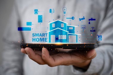 Akıllı ev arayüzü ile el ele tutuşan akıllı telefon bağlı cihazlar ve otomasyon teknolojisi gösteriyor. Modern yaşam, kolaylık, yenilik ve ev ağı yönetimi kavramı.