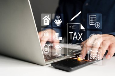 İşadamı bilgisayarını ve akıllı telefonunu dijital vergi dosyası, finans yönetimi ve muhasebe için kullanıyor. Sanal vergi simgeleri ve çevrimiçi araçlar mali planlama ve ödeme sistemlerini temsil etmektedir